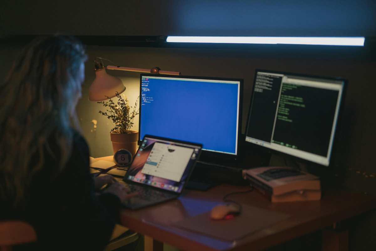Ce este un rootkit si de ce este greu de detectat_ Cum se ascunde in sistem si de ce reprezinta o amenintare majora_Femeie utilizand un laptop si computere la birou